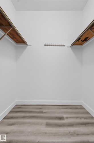 Wood-finish flooring with white baseboards and light-colored walls - #301 9809 110 St Nw, Edmonton, AB 