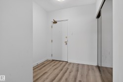Wood-finish flooring with white walls and a mirrored closet - 