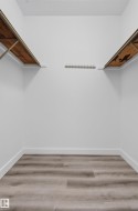 Wood-finish flooring with white baseboards and light-colored walls - 