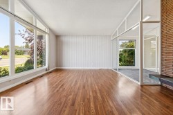 Bright solarium with natural light separates living room and dining room. - 
