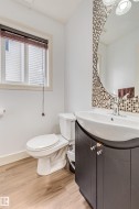 Wood-finish flooring, white walls, and a window with blinds - 