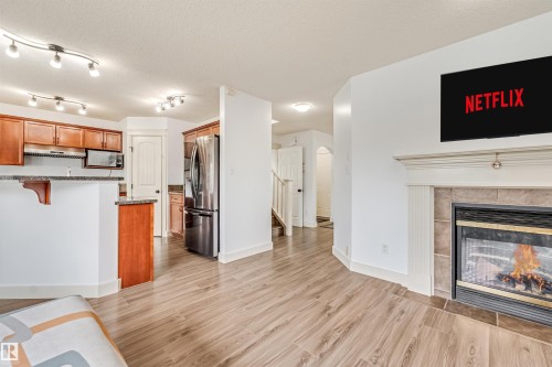 Kitchen featuring wood cabinetry, stainless steel appliances, and track lighting - 20324 48 Avenue Nw, Edmonton, AB 