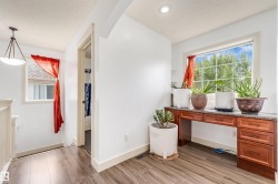 Wood-finish flooring, recessed lighting, built-in desk with cabinet storage, window with exterior scenery, and a ceiling-mounted light fixture - 