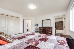 White interior walls, overhead light fixture, dual pane window, white six-panel closet doors, and dark wood-finish flooring in the bathroom - 
