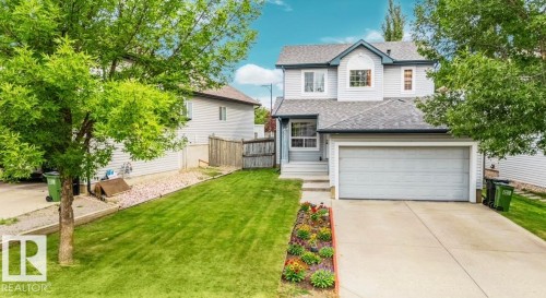 Two-story residence with light-colored siding, an attached two-car garage, and a concrete driveway - 20324 48 Avenue Nw, Edmonton, AB 