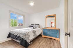 Bright room with a large window, wood-finish flooring, white walls, and a ceiling-mounted light fixture - 
