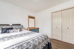 Wood-finish flooring, white walls, and bi-fold closet doors - 