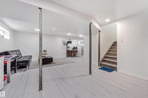 Brightly lit lower level featuring light wood-finish flooring, white painted walls, and recessed ceiling lighting - 20324 48 Avenue Nw, Edmonton, AB 
