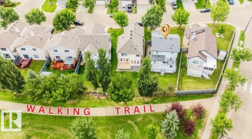 Property featuring a walking trail with green space, mature trees, and private backyard decks - 20324 48 Avenue Nw, Edmonton, AB 