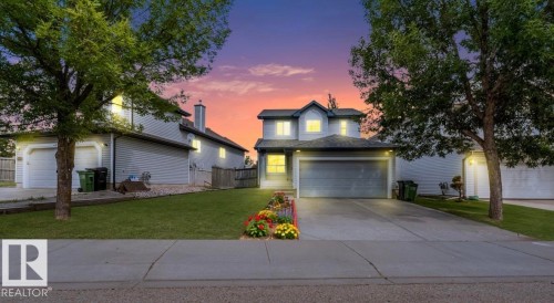 Two-story residence featuring light gray siding, a prominent attached garage, and a manicured front lawn - 20324 48 Avenue Nw, Edmonton, AB 