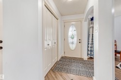 Entryway featuring a decorative oval glass door, wood-finish flooring, and built-in bi-fold closet doors - 