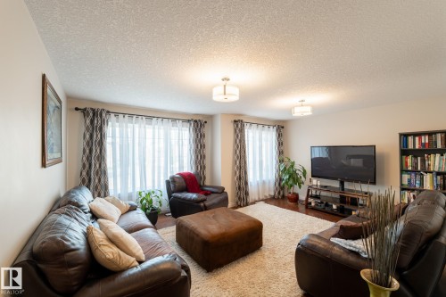 Recessed lighting fixtures, multiple windows with sheers, wood-finish flooring, and a built-in shelving unit - 914 Crystallina Nera Way Nw, Edmonton, AB 