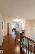 Hardwood flooring, wood railing with metal balusters, and overhead lighting - 