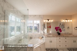 White shaker-style vanity with dual sinks and granite countertops - 