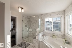 Glass-enclosed shower, built-in soaking tub, large window, tile flooring, and wall tile - 