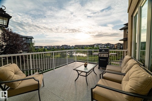 Expansive outdoor deck featuring a durable surface, white railing, and a large glass sliding door - 914 Crystallina Nera Way Nw, Edmonton, AB 