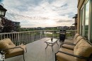 Expansive outdoor deck featuring a durable surface, white railing, and a large glass sliding door - 914 Crystallina Nera Way Nw, Edmonton, AB 