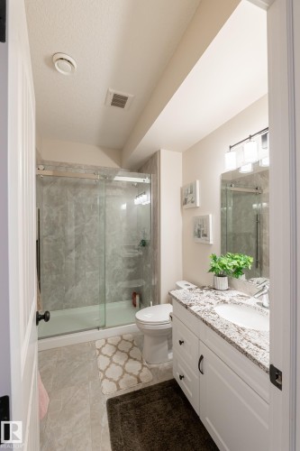 White shaker vanity with a stone countertop, undermount sink, and black hardware - 914 Crystallina Nera Way Nw, Edmonton, AB 