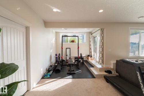 Recessed lighting, wood-finish interior door, integrated exercise space with rubber flooring, sliding glass door, and a large window with blinds - 914 Crystallina Nera Way Nw, Edmonton, AB 