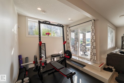 Recessed lighting illuminates this space, featuring a sliding glass door with a transom window above - 914 Crystallina Nera Way Nw, Edmonton, AB 