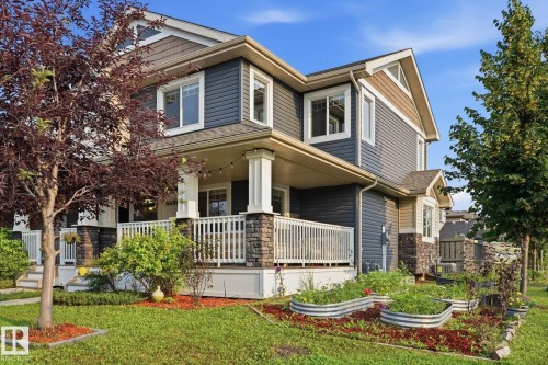 Two-story residence featuring a covered front porch with white railings and stone-wrapped columns - 17621 10 Avenue Sw, Edmonton, AB - Outdoor