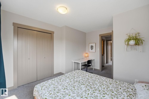 Recessed closet with bifold doors, neutral paint palette, and overhead flush-mount lighting - 17621 10 Avenue Sw, Edmonton, AB - Indoor Photo Showing Bedroom