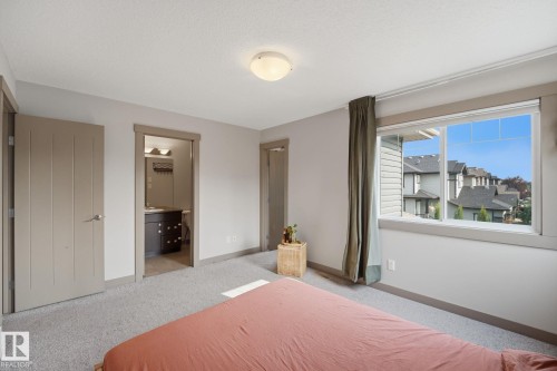 Carpeted room with a large windows, providing natural light - 17621 10 Avenue Sw, Edmonton, AB - Indoor Photo Showing Bedroom