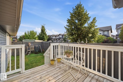 Orderly backyard featuring a wood deck with white railings, a privacy fence, a comfortable place for relaxation - 17621 10 Avenue Sw, Edmonton, AB - Outdoor With Deck Patio Veranda With Exterior