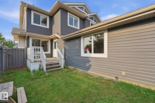 Multi-level rear exterior with gray siding, white trim windows, and a raised deck with steps - 17621 10 Avenue Sw, Edmonton, AB - Outdoor