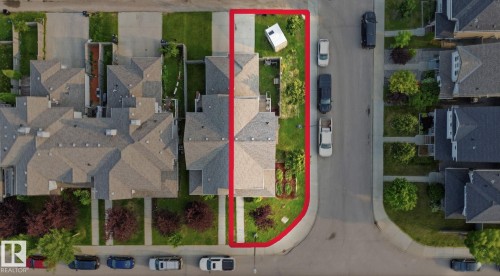 Aerial perspective showcasing a property with a paved driveway, front lawn, and mature landscaping - 17621 10 Avenue Sw, Edmonton, AB - 