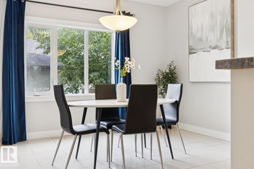 Large picture window, pendant light fixture, light tile flooring, built-in countertop, white wall finishes - 9919 79 Street Nw, Edmonton, AB 