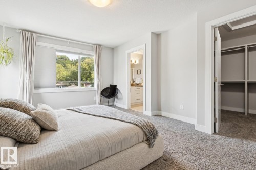 Plush carpet flooring, recessed window, built-in shelving in closet, light gray wall paint, and overhead flush-mount lighting - 9919 79 Street Nw, Edmonton, AB 