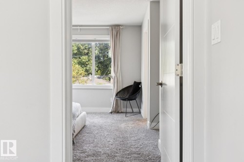 Plush carpeting, a large window, and light gray wall tones - 9919 79 Street Nw, Edmonton, AB 