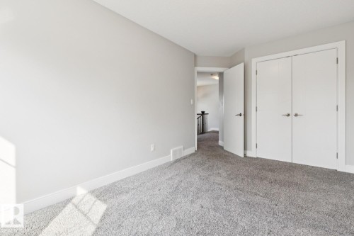 Plush gray carpeting, white trim, and a white interior door with brushed nickel hardware - 9919 79 Street Nw, Edmonton, AB 