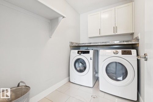 Laundry area with overhead white cabinetry, a single white wall shelf, and a countertop surface - 9919 79 Street Nw, Edmonton, AB 