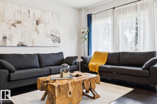 Deep wood-finish flooring, light-toned walls, and large windows with sheer coverings - 9919 79 Street Nw, Edmonton, AB 
