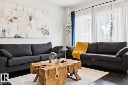 Deep wood-finish flooring, light-toned walls, and large windows with sheer coverings - 