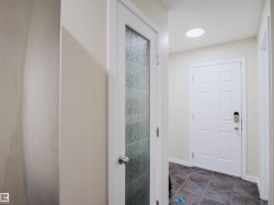 Entryway with tiled flooring, white paneled door, and recessed lighting - 