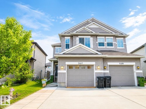 Two-story exterior with horizontal siding, dual garage doors, and a concrete driveway - 5407 14 Avenue Sw, Edmonton, AB 