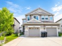 Two-story exterior with horizontal siding, dual garage doors, and a concrete driveway - 5407 14 Avenue Sw, Edmonton, AB 