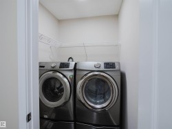 Laundry closet featuring a built-in wire shelf and a front-loading washer and dryer - 