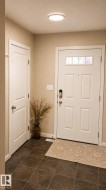 White paneled front door with upper transom windows and smart lock hardware - 
