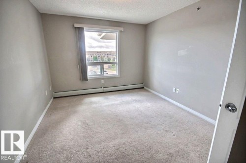 Recessed ceiling light, neutral wall paint, carpeted flooring, window with vertical blinds, baseboard heating - #7428 7327 South Terwillegar Dr Nw, Edmonton, AB 