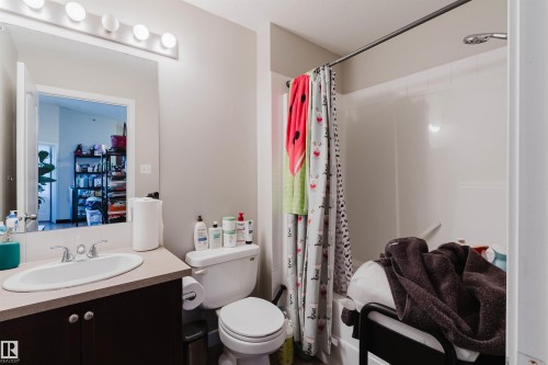 Bathroom featuring a single vanity with an oval sink, a toilet, and a shower-over-tub combination - #7428 7327 South Terwillegar Dr Nw, Edmonton, AB 