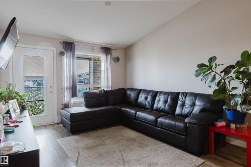 Vaulted ceiling, wood-finish flooring, white door with glass panel, recessed lighting, and window with exterior view - #7428 7327 South Terwillegar Dr Nw, Edmonton, AB 