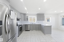 Kitchen featuring white tile flooring, stainless steel appliances, light gray cabinetry, and recessed lighting - 