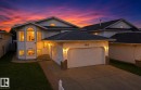 White siding exterior with a prominent two-car garage, stone accents, and a brick paver walkway - 3015 37 Street Nw, Edmonton, AB 