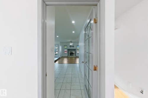 Light-colored tile flooring, recessed lighting, and a decorative glass-paneled door - 3015 37 Street Nw, Edmonton, AB 
