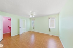 Wood-finish flooring throughout, two windows with blinds, and a built-in ceiling fan with integrated lighting - 