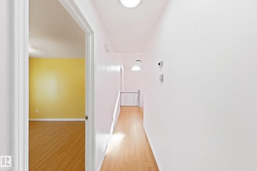 Wood-finish flooring throughout, white painted walls, and ceiling-mounted light fixtures - 3015 37 Street Nw, Edmonton, AB 